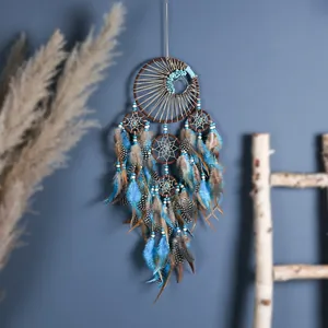 Attrape-rêves bleu fait main avec plumes tachetées et perles turquoise décoration.