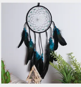 Gros plan d'un attrape-rêves bohème avec anneau noir, perles et plumes turquoise