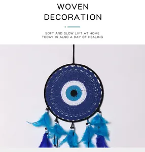 Detailed view of a handmade evil eye dreamcatcher with vibrant blue feathers and beads