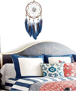Atrapasueños hecho a mano con plumas azules para decoración de pared en un dormitorio