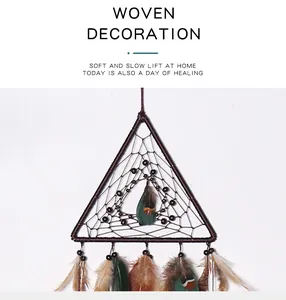 Detail view of a triangular woven dreamcatcher with natural feathers and beads