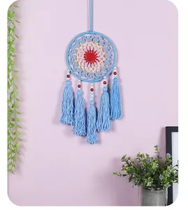 Detailed view of a blue knitted dreamcatcher wall hanging with long tassels and beads