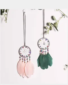Detail of handmade dream catchers with colorful crushed stones and soft feathers