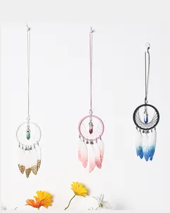 Detailed view of hand-woven dreamcatchers with ombre feathers and crystal pendants