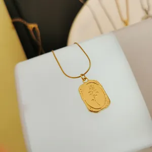 Nahaufnahme einer goldenen Vintage-Halskette mit rechteckigem Rosengravur-Anhänger