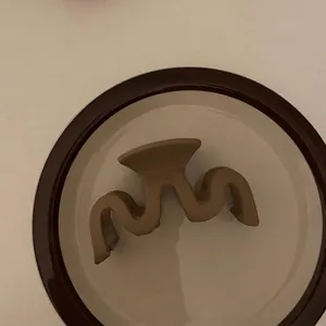 Dettaglio di un fermaglio per capelli geometrico opaco color tè al latte per un look elegante