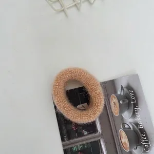 Nahaufnahme eines beigen gestrickten Haargummis mit weicher Wolltextur für Damen