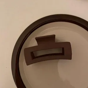 Primo piano di un fermaglio geometrico marrone opaco su un piatto di ceramica deco