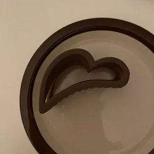 Dettaglio di una pinza per capelli marrone opaca a forma di cuore dalla finitura liscia