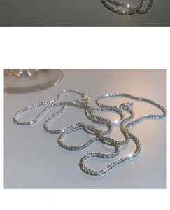 Macro view of shimmering silver stardust chain necklace with sparkling light effects