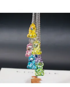 Detailed macro view showing colorful faceted acrylic bear pendants on silver necklaces