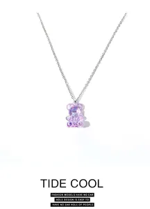 Detailed macro shot of a translucent purple gummy bear pendant on a silver-toned chain.