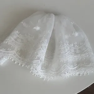Detailed close-up of white elegant French lace hair clip with floral embroidery patterns