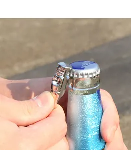 Close-up of skull bottle opener necklace used to open a beer bottle