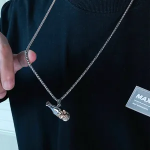 Close-up of a unique skull beer bottle pendant necklace worn on a black T-shirt