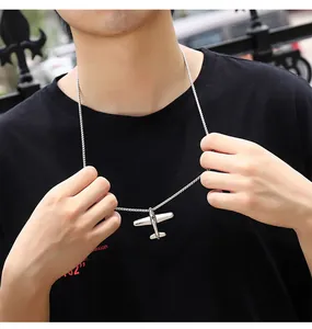 Primer plano de un collar hip-hop con colgante de avión en acero inoxidable plateado en modelo