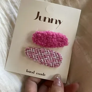 Détail en gros plan d'un ensemble de barrettes à cheveux en tweed rose et sherpa doux
