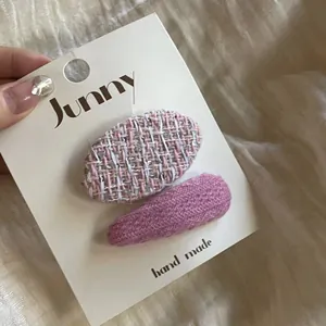 Vue détaillée des barrettes en tweed rose et tricot sur carte de marque