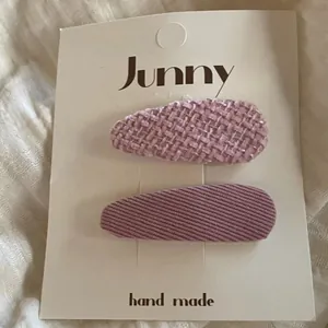 Gros plan de barrettes à cheveux roses en tweed et velours pour filles sur carton