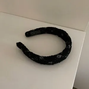 Vista ravvicinata di una fascia in maglia nera soffice con puntini argentati brillanti