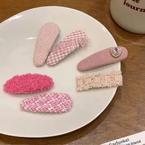 Vue détaillée de barrettes BB en tweed rose et décorées sur une assiette en céramique