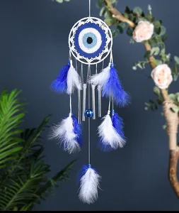 Detalle del atrapasueños de Ojo Turco azul y blanco con tubos de metal y plumas