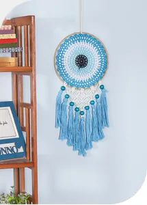 Detailed view of a handmade blue Evil Eye dreamcatcher with knit patterns and tassels