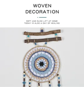 Detalle de un atrapasueños bohemio hecho a mano con diseño de ojo turco azul y blanco.