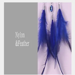 Vue détaillée des plumes bleues et de la perle mauvais œil sur l'attrape-rêve artisanal