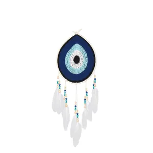 Handmade Bohemian crochet evil eye dreamcatcher featuring white feathers and wooden beads