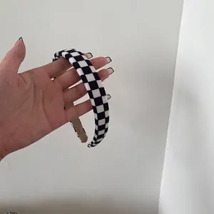 Primo piano di cerchietto a scacchi bianco e nero largo 2 cm con trama