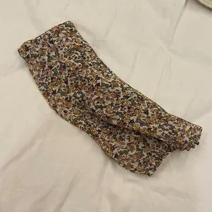 Detalle que muestra el estampado floral vintage en manguitos de protección solar de gasa