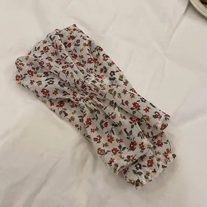 Vista detallada del elegante estampado floral en manguitos de gasa para protección solar