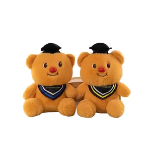 Dos ositos de peluche de graduación marrones con birretes negros y bandas azules