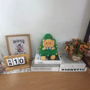Süßer Weihnachtsbaum-Plüschbär auf einem rustikalen Holzschreibtisch mit Requisiten
