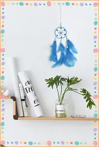 Atrapasueños azul de ojo turco con plumas colgado en pared blanca sobre estante