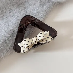 Elegante amberkleurige haarklem met decoratieve zwart-witte polkadot strik voor dames