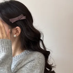 Vue détaillée d'une barrette à cheveux nœud marron à pois de style français portée par un mannequin