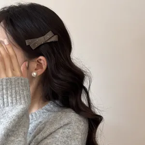 Gros plan d'une jolie pince à cheveux nœud marron à pois sur des cheveux ondulés