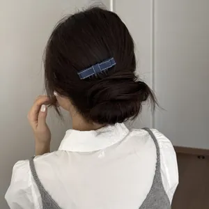 Detailed close-up of a blue denim bow hair clip insert comb in a bun hairstyle.