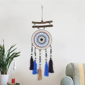 Atrapasueños bohemio artesanal con ojo turco, palos de madera y borlas coloridas.