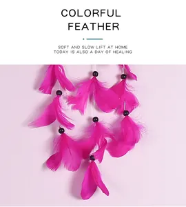 Gros plan détaillé de plumes roses vibrantes et de perles sur un attrape-rêves fait main