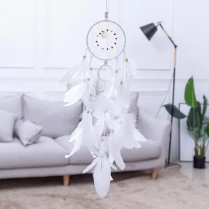 Gedetailleerd overzicht van een witte dromenvanger met veren en kralen voor decor