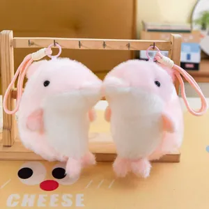 Close-up of two cute pink plush dolphin pendants hanging on a wooden rack