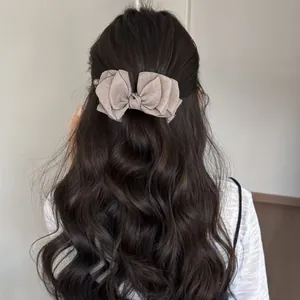 Detalle de pinza para el pelo con lazo de organza multicapa en cabello ondulado