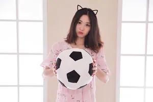 Soft large plush soccer ball toy pillow held by an Asian model in an indoor room