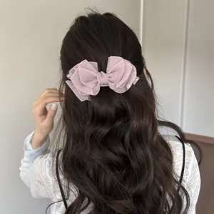 Pinza para el cabello con lazo de organza rosa multicapa en cabello largo ondulado