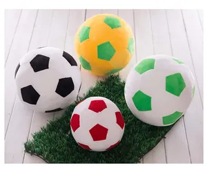Collection of colorful plush soccer ball toys displayed on realistic artificial green grass