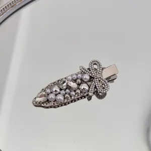Detailaufnahme einer luxuriösen silbernen Haarspange mit weißen Perlen und Strass
