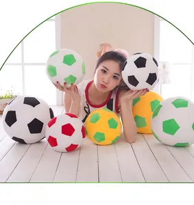 Various soccer ball plush pillows shown with a model for size comparison
